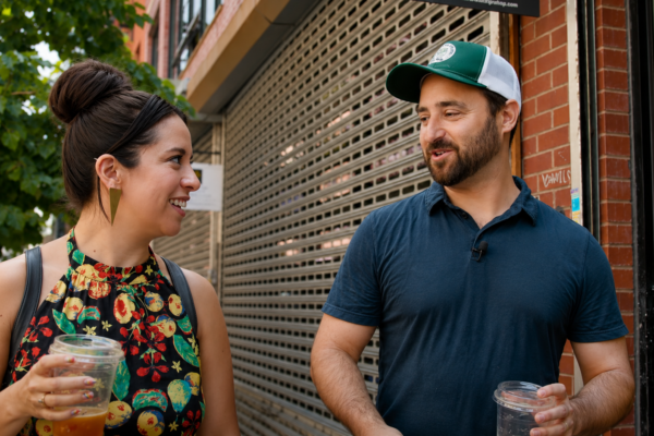 man and woman walking down the street drinking coffee